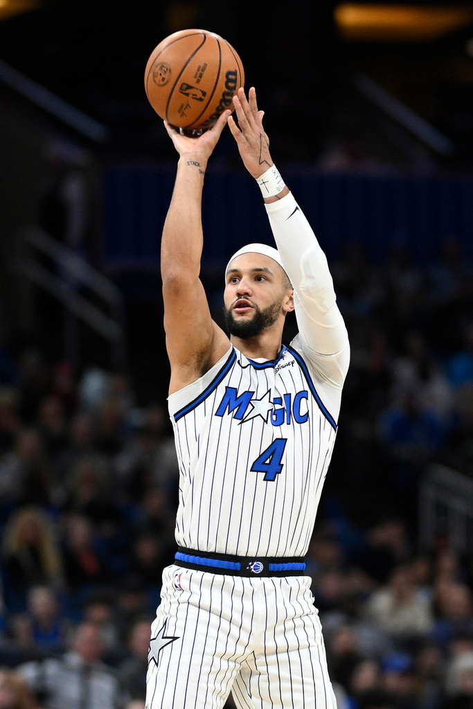 Orlando Magic guard Jalen Suggs (4) goes up to shoot a 3-pointer during the first half of an NBA basketball game against the Cleveland Cavaliers, Saturday, Jan. 24, 2026, in Orlando, Fla. (AP Photo/Phelan M. Ebenhack)