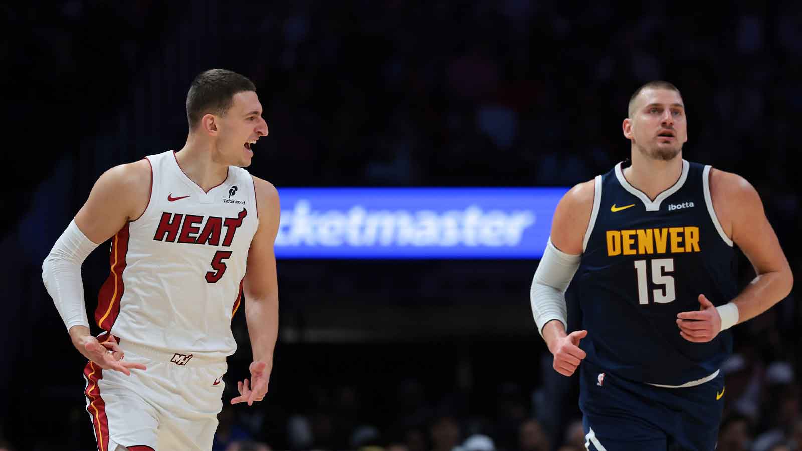 Miami Heat forward Nikola Jovic (5) reacts toward Denver Nuggets center Nikola Jokic (15) after scoring during the first quarter at Kaseya Center.