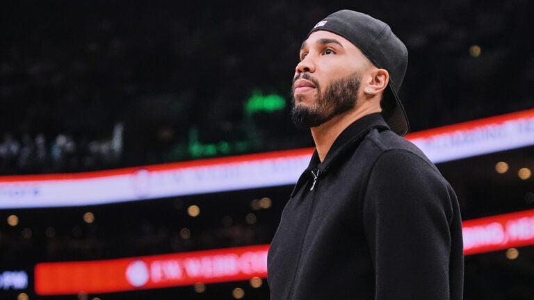 Boston Celtics forward Jayson Tatum, who is out with an injury, stands near the bench during a time out in the first half of an NBA basketball game against the Denver Nuggets, Wednesday, Jan. 7, 2026, in Boston.