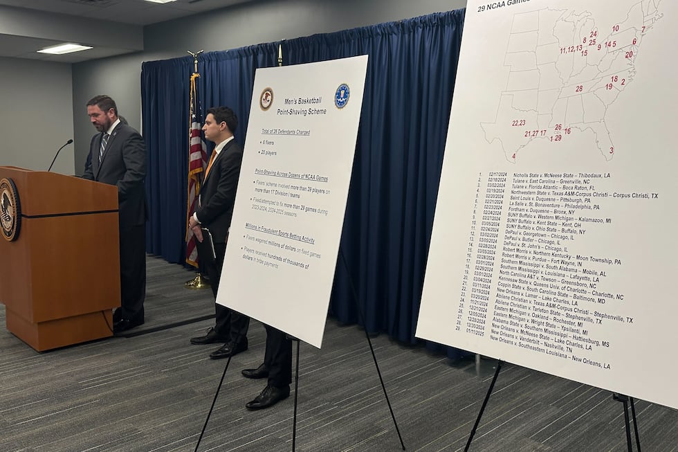 Information is displayed during a news conference to announce charges against 20 people...