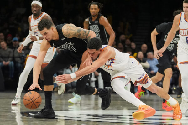 Phoenix Suns' Devin Booker, right, fights for control of the all with Brooklyn Nets' Michael Porter Jr. during the second half of an NBA basketball game against the Phoenix Suns Monday, Jan. 19, 2026, in New York. (AP Photo/Frank Franklin II)