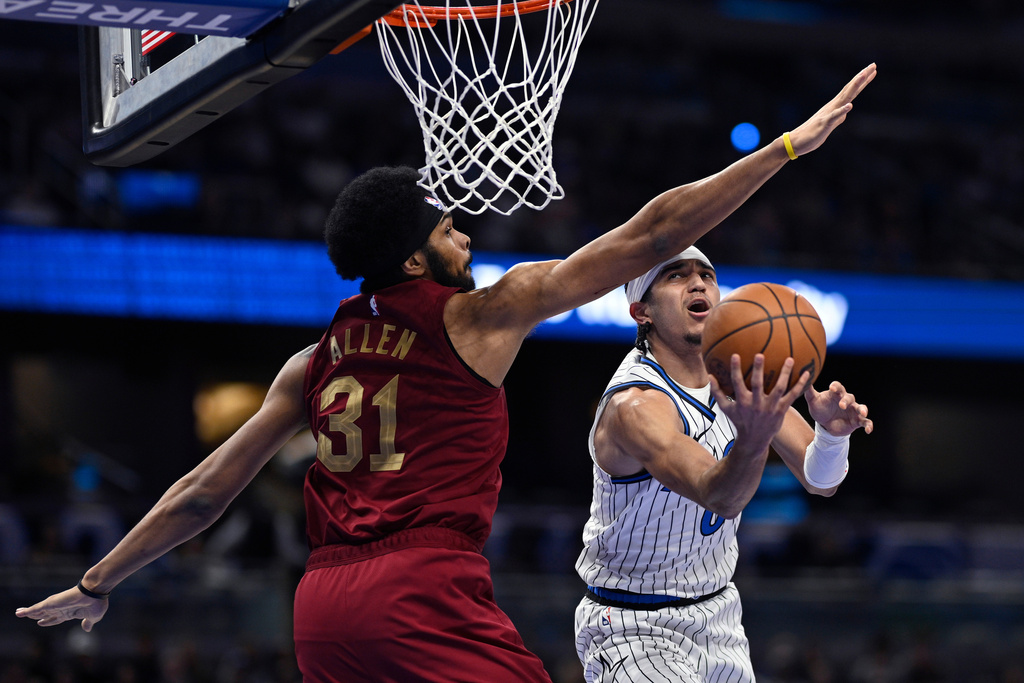 Orlando Magic guard Anthony Black (0) goes up to shoot as Cleveland Cavaliers center Jarrett Allen (31) defends during the first half of an NBA basketball game, Saturday, Jan. 24, 2026, in Orlando, Fla. (AP Photo/Phelan M. Ebenhack)
