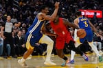 Portland Trail Blazers guard Jrue Holiday (5) moves the ball while defended by Golden State Warriors guard De'Anthony Melton (8) during the first half of an NBA basketball game, Tuesday, Jan. 13, 2026, in San Francisco.