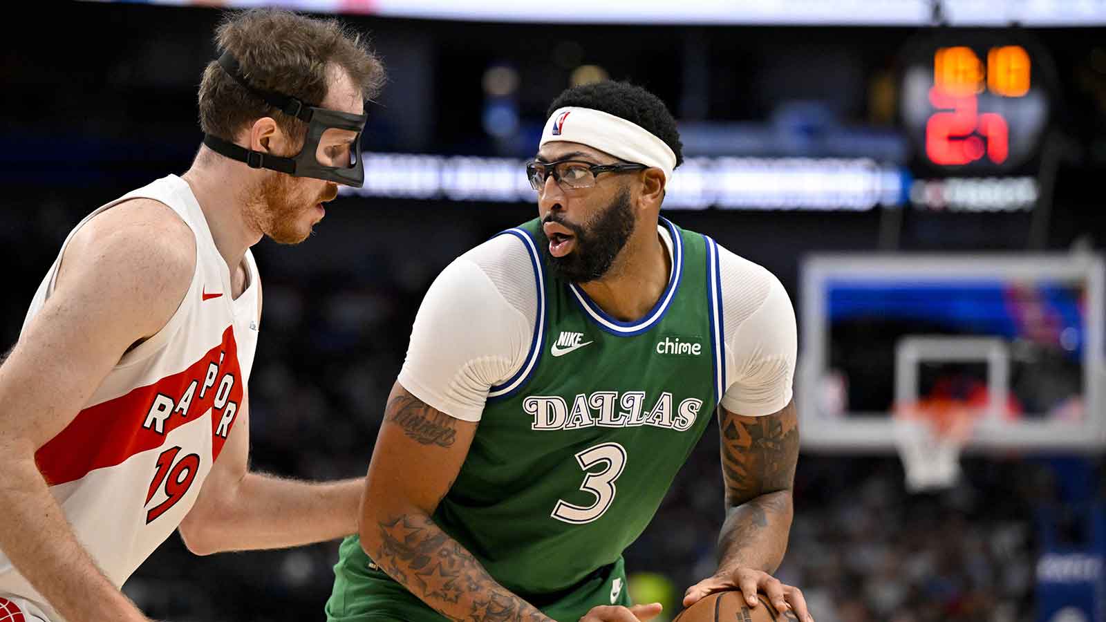 Mavericks forward Anthony Davis (3) looks to move the ball past Toronto Raptors center Jakob Poeltl (19) during the game between the Mavericks and the Raptors at the American Airlines Center