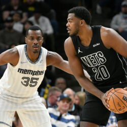 Brooklyn Nets center Day'ron Sharpe (20) handles the ball against Memphis Grizzlies center Christian Koloko (35) in the first half of an NBA basketball game Sunday, Jan. 11, 2026, in Memphis, Tenn. (AP Photo/Brandon Dill)