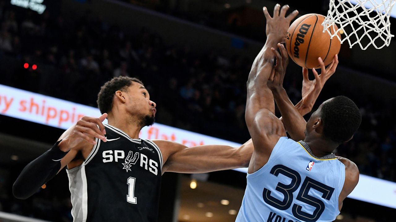 San Antonio Spurs forward Victor Wembanyama (1) and Memphis Grizzlies center Christian Koloko (35) reach for the ball in the first half of an NBA basketball game Tuesday, Jan. 6, 2026, in Memphis, Tenn. (AP Photo/Brandon Dill)