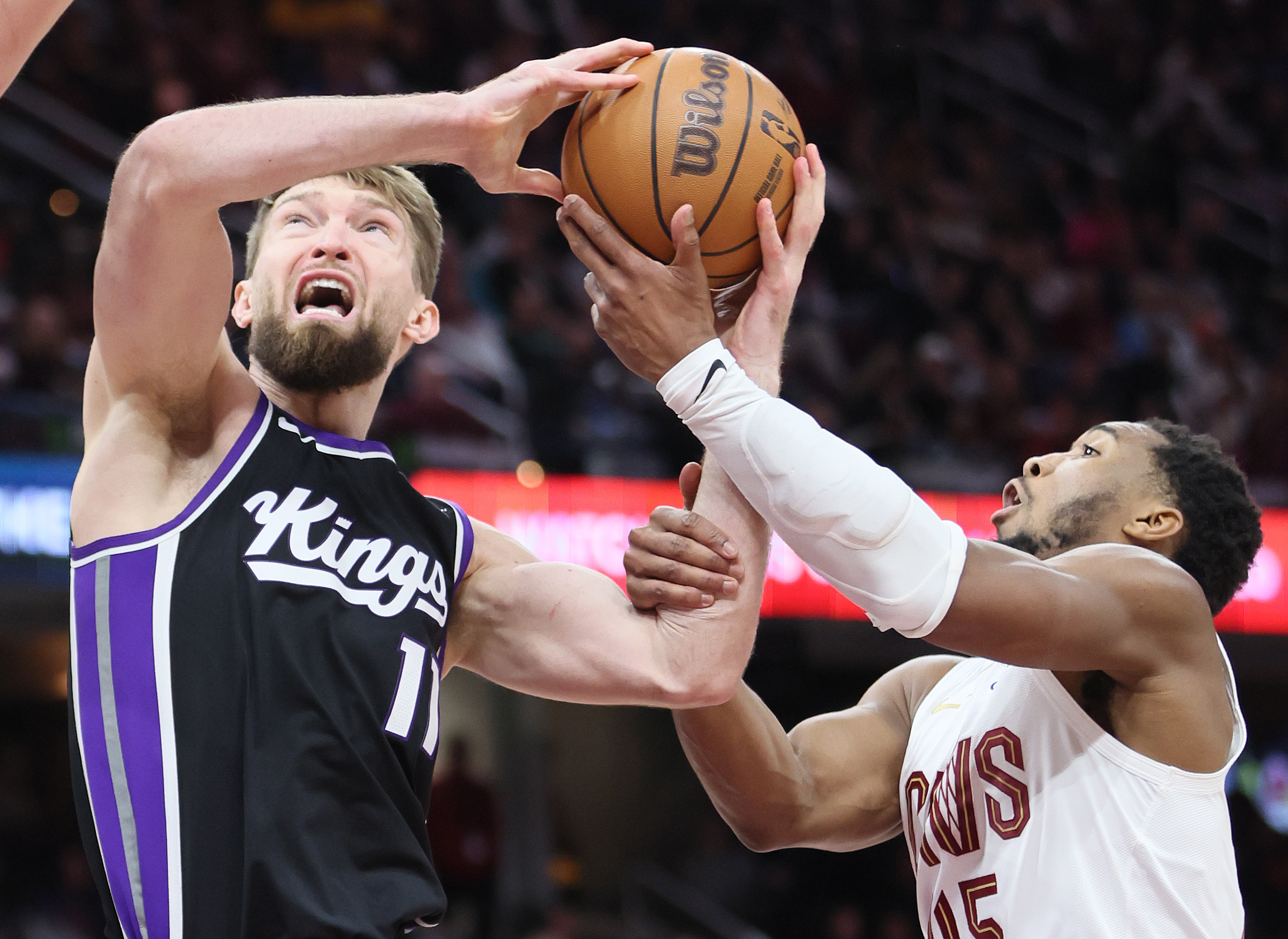 Cleveland Cavaliers guard Donovan Mitchell fouls Sacramento Kings forward Domantas Sabonis on his drive to the basket in the second half. 