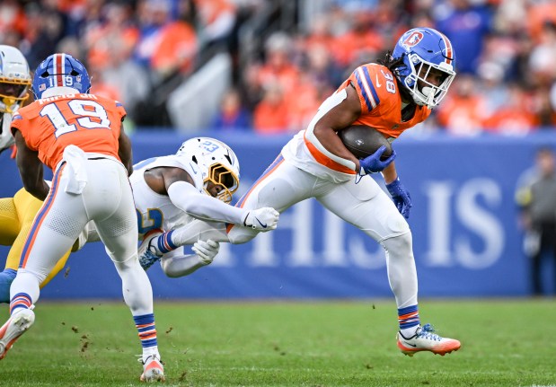 DENVER , CO - JANUARY 4: Jaleel McLaughlin (38) of the Denver Broncos sheds Tony Jefferson (23) of the Los Angeles Chargers during the third quarter at Empower Field at Mile High in Denver, Colorado on Sunday, January 4, 2026. (Photo by AAron Ontiveroz/The Denver Post)