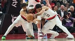Houston Rockets guard Josh Okogie, center, fights for the ball with Portland Trail Blazers forward Rayan Rupert, left, and forward Toumani Camara during the first half of an NBA basketball game in Portland, Ore., Wednesday, Jan. 7, 2026.