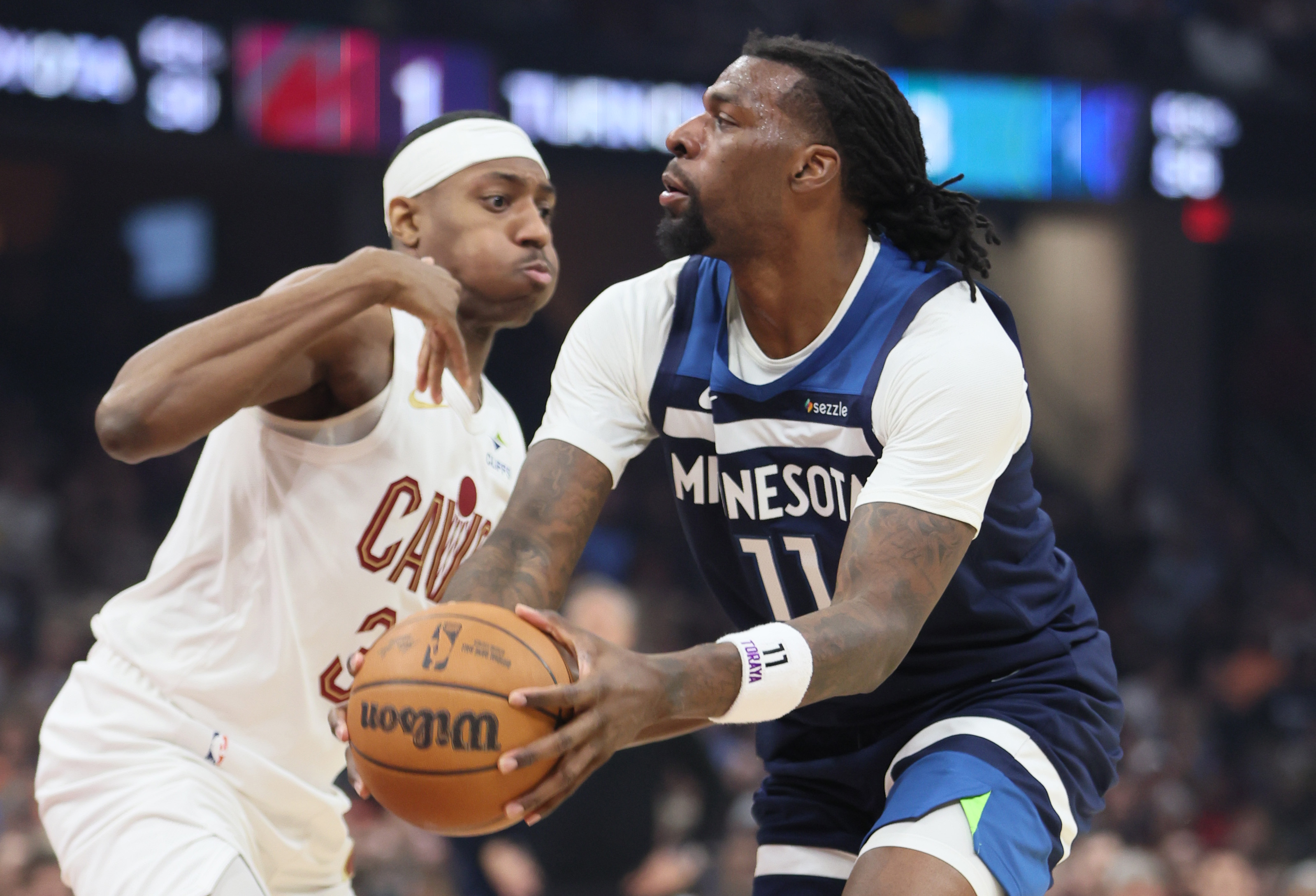 Minnesota Timberwolves center Naz Reid looks to make a pass guarded by Cleveland Cavaliers forward Nae'qwan Tomlin in the first half at Rocket Arena. 