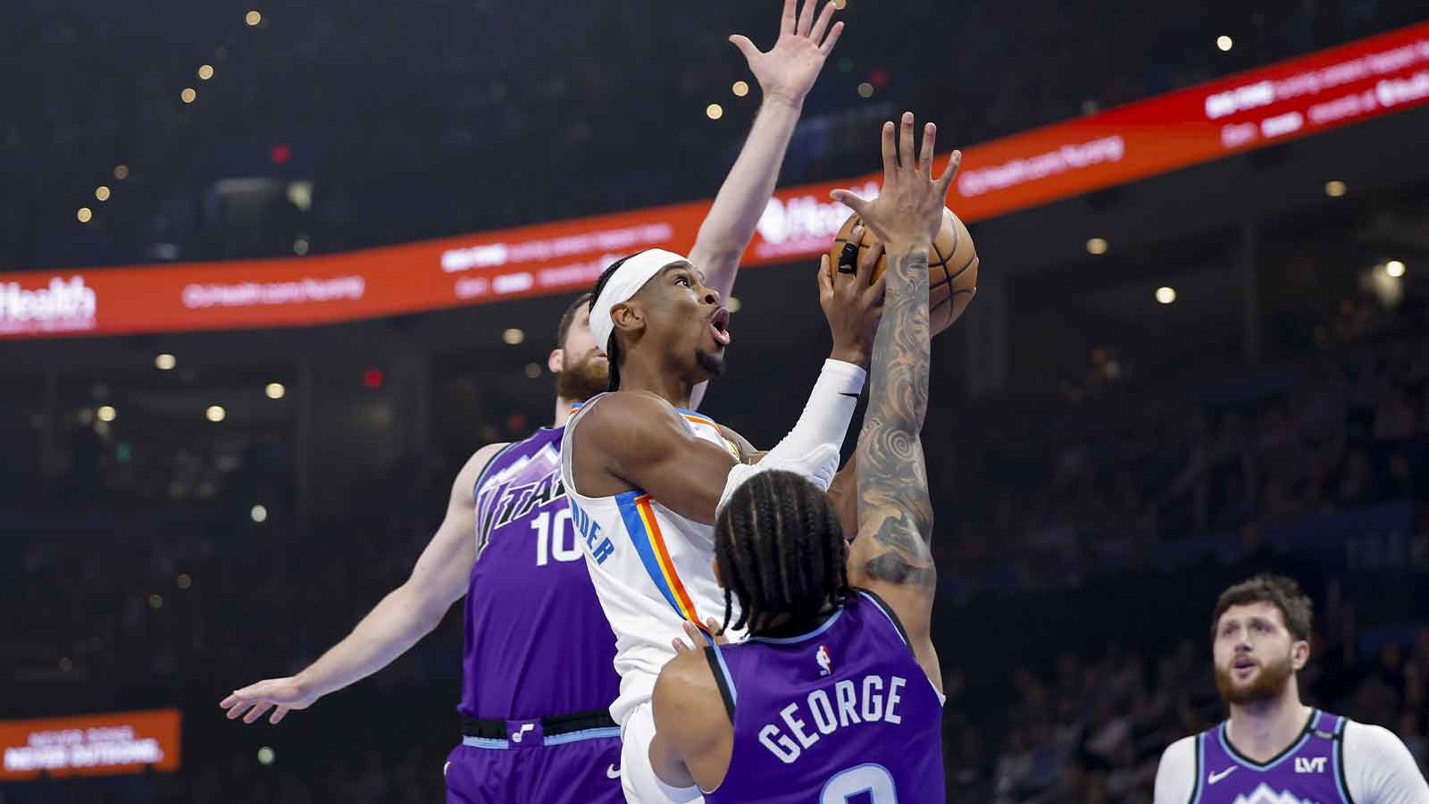 Thunder guard Shai Gilgeous-Alexander (2) goes up for a basket between Utah Jazz guard/forward Svi Mykhailiuk (10) and guard Keyonte George (3) during the first quarter at Paycom Center