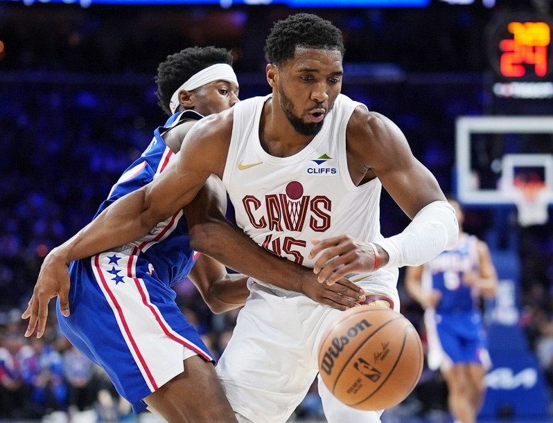Cleveland Cavaliers' Donovan Mitchell, right, battles for the ball against Philadelphia 76ers' Vj Edgecombe during the first half of an NBA basketball game Wednesday, Jan. 14, 2026, in Philadelphia. 