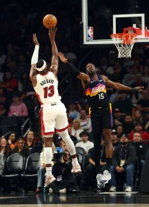 Jan 25, 2026; Phoenix, Arizona, USA; Miami Heat center Bam Adebayo (13) shoots the ball against Phoenix Suns center Mark Williams (15) in the first half at Mortgage Matchup Center. Mandatory Credit: Mark J. Rebilas-Imagn Images