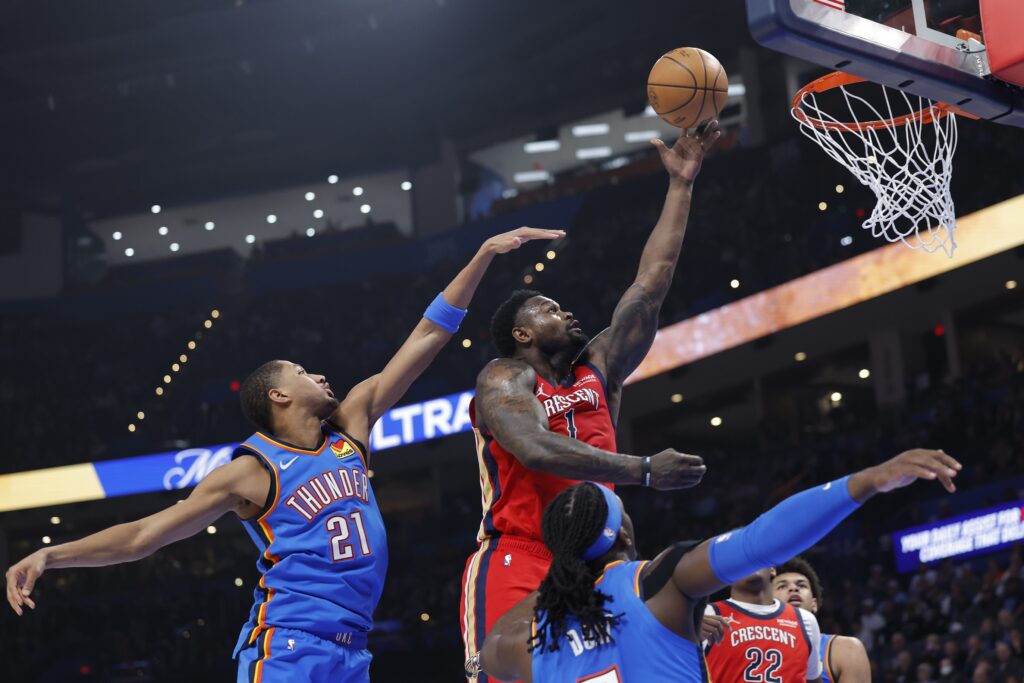 Jan 27, 2026; Oklahoma City, Oklahoma, USA; New Orleans Pelicans forward Zion Williamson (1) goes up for a basket between Oklahoma City Thunder guard Aaron Wiggins (21) and guard Luguentz Dort (5) during the second quarter at Paycom Center. Mandatory Credit: Alonzo Adams-Imagn Images