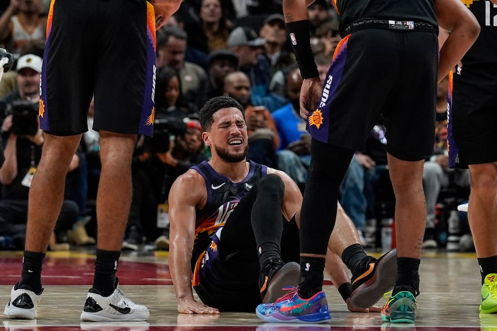 Phoenix Suns guard Devin Booker (1) winces in pain during the second half of an NBA basketball...