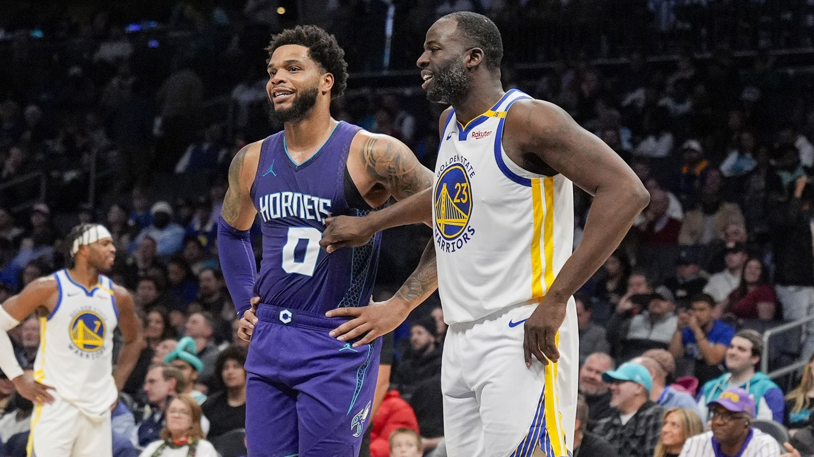 Warriors forward Draymond Green (23) chats with Charlotte Hornets forward Kon Knueppel at the free throw line during the second half at Spectrum Center