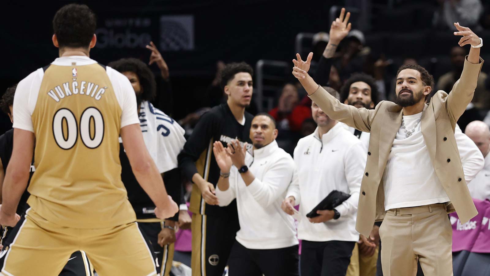 Newly acquired Washington Wizards guard Trae Young (R) celebrates from the bench with Washington Wizards forward Tristan Vukcevic (00) against the New Orleans Pelicans in the second half at Capital One Arena.