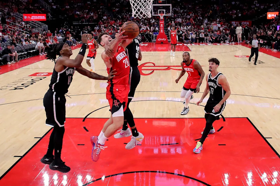 Oct 27, 2025; Houston, Texas, USA; Houston Rockets center Alperen Sengun (28) is fouled while shooting inside by Brooklyn Nets center Nic Claxton (33) during the third quarter at Toyota Center. Mandatory Credit: Erik Williams-Imagn Images