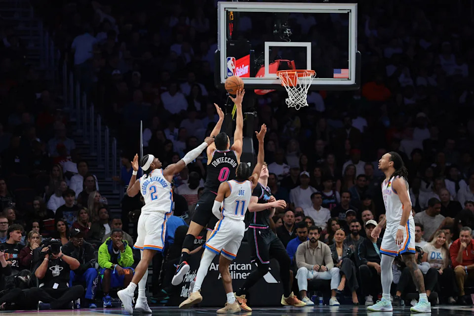 Jan 17, 2026; Miami, Florida, USA; Miami Heat forward Simone Fontecchio (0) drives to the basket against Oklahoma City Thunder guard Shai Gilgeous-Alexander (2) and guard Isaiah Joe (11) during the second quarter at Kaseya Center. Mandatory Credit: Sam Navarro-Imagn Images