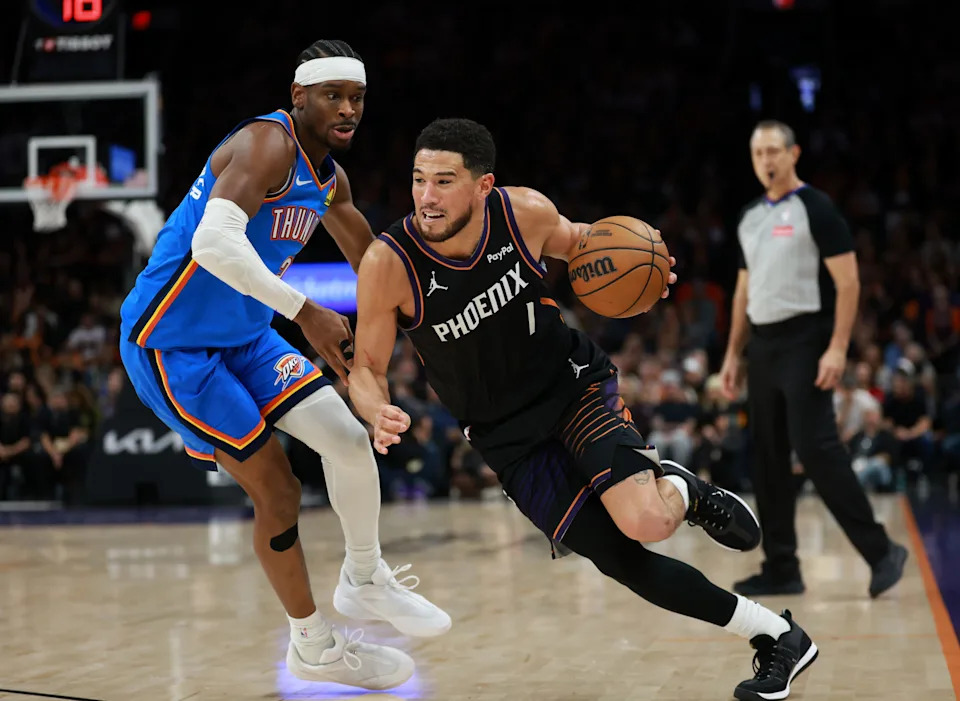 Jan 4, 2026; Phoenix, Arizona, USA; Phoenix Suns guard Devin Booker (1) drives to the basket against Oklahoma City Thunder guard Shai Gilgeous-Alexander (2) in the second half at Mortgage Matchup Center. Mandatory Credit: Mark J. Rebilas-Imagn Images