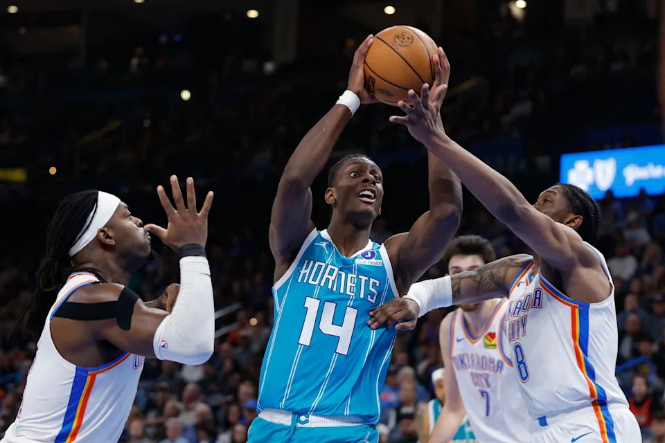 Jan 5, 2026; Oklahoma City, Oklahoma, USA; Charlotte Hornets forward Moussa Diabate (14) goes up for a basket between Oklahoma City Thunder guard Luguentz Dort (5) and guard Jalen Williams (8) during the second half at Paycom Center. Mandatory Credit: Alonzo Adams-Imagn Images