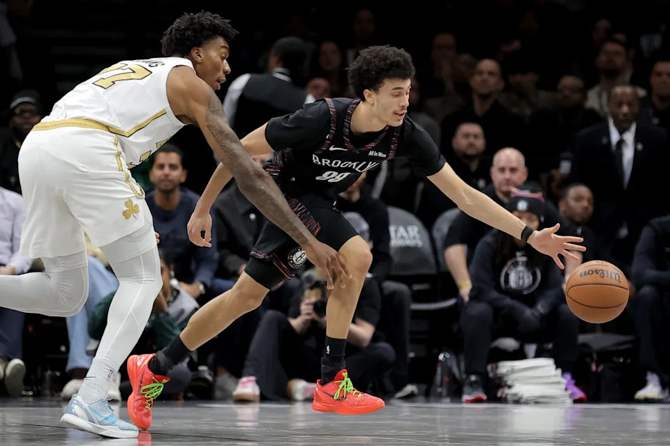 Jan 23, 2026; Brooklyn, New York, USA; Brooklyn Nets guard Nolan Traore (88) fights for a loose ball against Boston Celtics forward Amari Williams (77) during double overtime at Barclays Center. Mandatory Credit: Brad Penner-Imagn Images