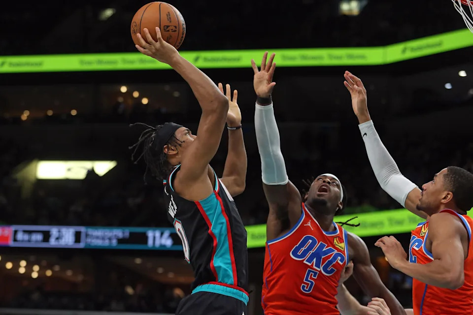 Jan 9, 2026; Memphis, Tennessee, USA; Memphis Grizzlies forward Jaylen Wells (0) shoots as Oklahoma City Thunder guard Luguentz Dort (5) and guard Aaron Wiggins (21) defend during the fourth quarter at FedExForum. Mandatory Credit: Petre Thomas-Imagn Images