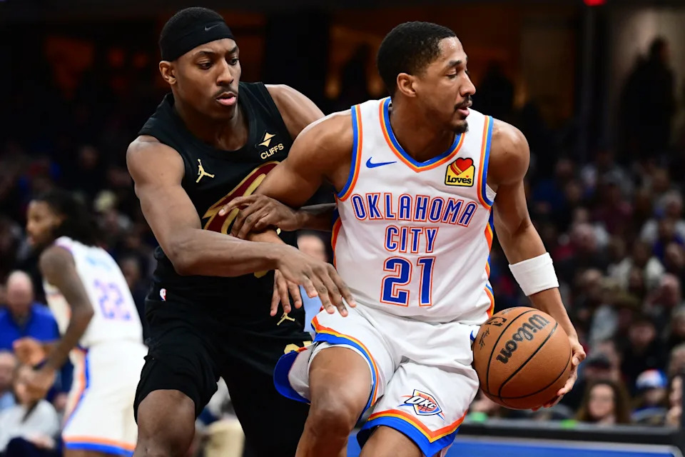 Jan 19, 2026; Cleveland, Ohio, USA; Oklahoma City Thunder guard Aaron Wiggins (21) controls the ball in front of Cleveland Cavaliers forward Nae'qwan Tomlin (35) during the second half at Rocket Arena. Mandatory Credit: Ken Blaze-Imagn Images