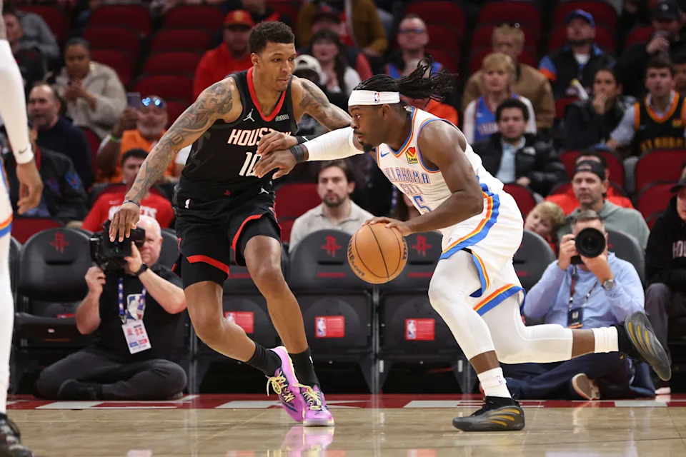 Jan 15, 2026; Houston, Texas, USA; Oklahoma City Thunder guard Luguentz Dort (5) drives with the ball as Houston Rockets forward Jabari Smith Jr. (10) defends during the first quarter at Toyota Center. Mandatory Credit: Troy Taormina-Imagn Images