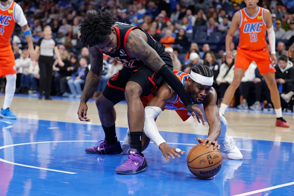 Jan 25, 2026; Oklahoma City, Oklahoma, USA; Toronto Raptors guard Jamal Shead (23) and Oklahoma City Thunder guard Shai Gilgeous-Alexander (2) fight for a loose ball during the second half at Paycom Center. Mandatory Credit: Alonzo Adams-Imagn Images