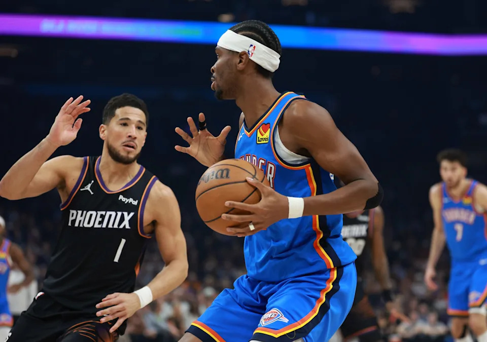 Jan 4, 2026; Phoenix, Arizona, USA; Oklahoma City Thunder guard Shai Gilgeous-Alexander (2) against Phoenix Suns guard Devin Booker (1) in the first half at Mortgage Matchup Center. Mandatory Credit: Mark J. Rebilas-Imagn Images