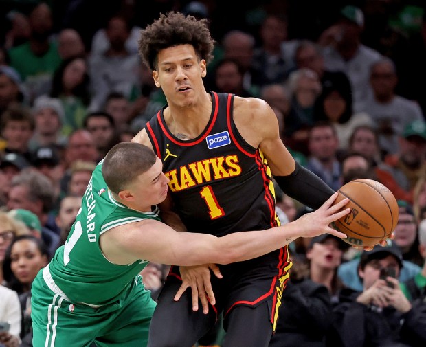 Boston Celtics guard Payton Pritchard (11) reaches around Atlanta Hawks forward Jalen Johnson during the second half of an NBA game at the TD Garden. (Photo By Matt Stone/Boston Herald)