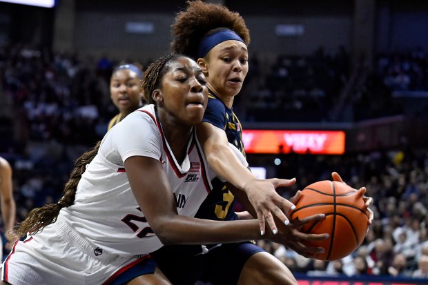UConn forward Serah Williams, left, is pressured by Notre Dame guard Hannah Hidalgo, right, on Monday, Jan. 19, 2026, in Storrs, Conn. (AP Photo/Jessica Hill)