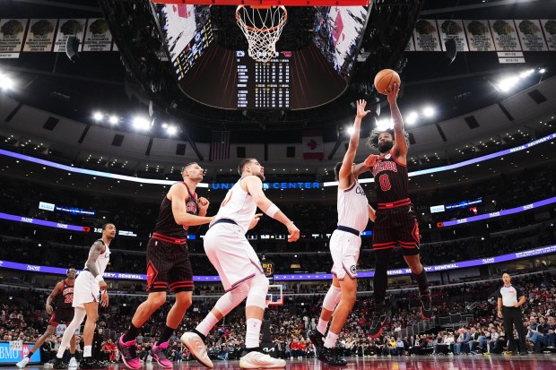 Chicago Bulls guard Coby White, right, drives to the basket against LA Clippers guard Kobe Sanders during the first half of an NBA basketball game in Chicago, Tuesday, Jan. 20, 2026. (AP Photo/Nam Y. Huh)