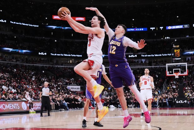 Chicago Bulls guard Josh Giddey, left, drives to the basket past Los Angeles Lakers forward Jake LaRavia during the second half on Monday, Jan. 26, 2026, in Chicago. (AP Photo/Nam Y. Huh)