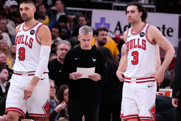 Chicago Bulls head coach Billy Donovan, center, reads a note during the first half of an NBA basketball game against the Los Angeles Lakers in Chicago, Monday, Jan. 26, 2026. (AP Photo/Nam Y. Huh)