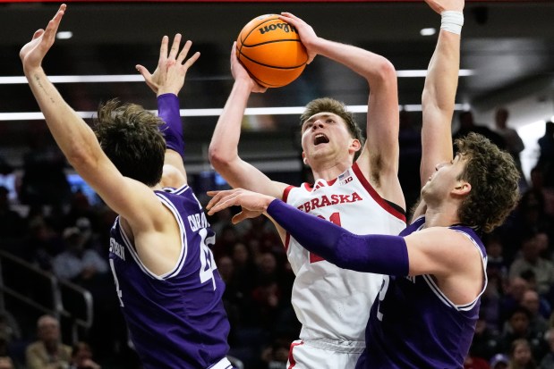 Nebraska forward Pryce Sandfort, center, shoots against Northwestern guard Angelo Ciaravino, left, and forward Nick Martinelli during the first half of an NCAA college basketball game in Evanston, Ill., Saturday, Jan. 17, 2026. (AP Photo/Nam Y. Huh)
