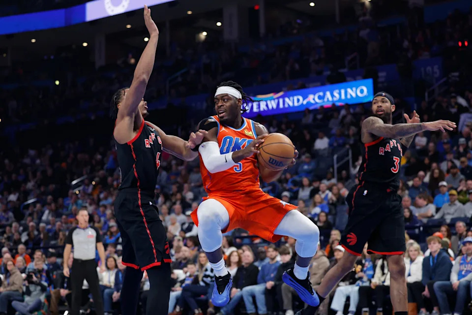 Jan 25, 2026; Oklahoma City, Oklahoma, USA; Oklahoma City Thunder guard Luguentz Dort (5) passes as Toronto Raptors forward/guard Scottie Barnes (4) defend during the second quarter at Paycom Center. Mandatory Credit: Alonzo Adams-Imagn Images