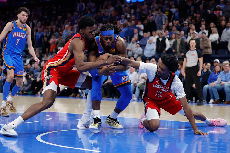 Jan 27, 2026; Oklahoma City, Oklahoma, USA; New Orleans Pelicans center Yves Missi (21) and forward Herbert Jones (2) fight for the ball against Oklahoma City Thunder guard Luguentz Dort (5) during the second half at Paycom Center. Mandatory Credit: Alonzo Adams-Imagn Images