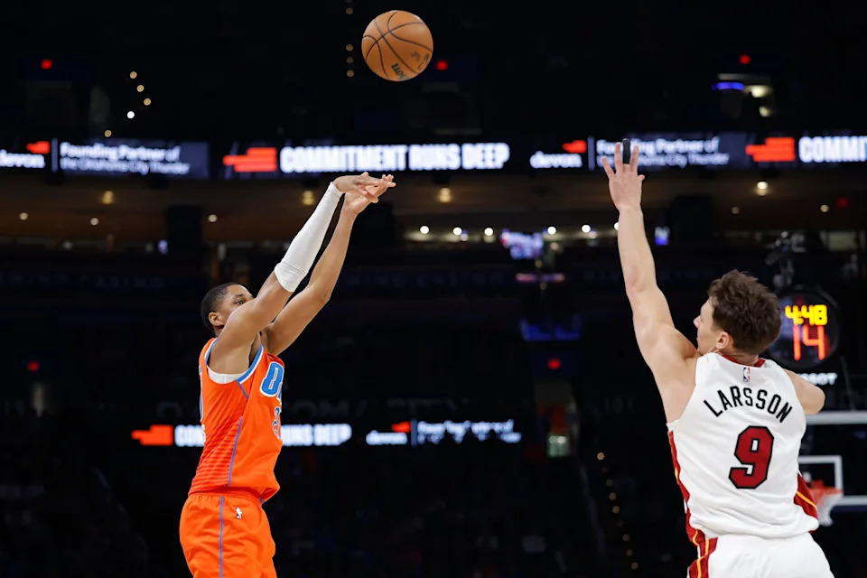 Jan 11, 2026; Oklahoma City, Oklahoma, USA; Oklahoma City Thunder guard Aaron Wiggins (21) shoots a three point basket over Miami Heat guard Pelle Larsson (9) during the second half at Paycom Center. Mandatory Credit: Alonzo Adams-Imagn Images