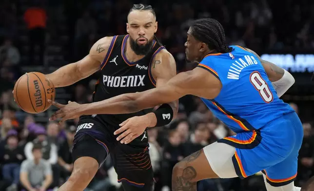 Phoenix Suns forward Dillon Brooks drives on Oklahoma City Thunder guard Jalen Williams (8) during the first half of an NBA basketball game, Sunday, Jan. 4, 2026, in Phoenix. (AP Photo/Rick Scuteri)