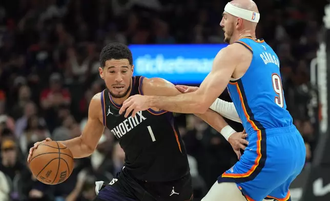 Phoenix Suns guard Devin Booker drives on Oklahoma City Thunder guard Alex Caruso (9) during the first half of an NBA basketball game, Sunday, Jan. 4, 2026, in Phoenix. (AP Photo/Rick Scuteri)