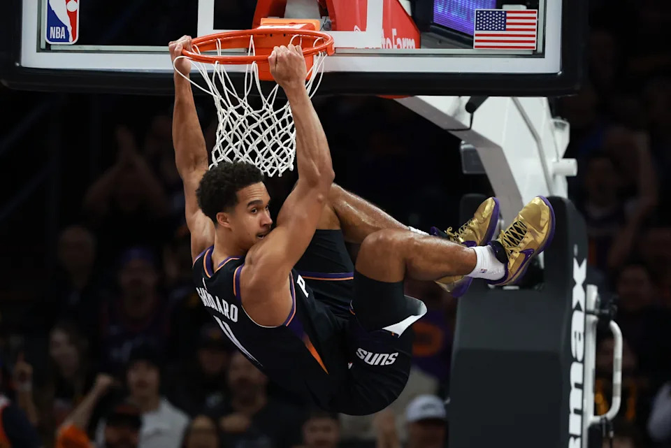 Jan 4, 2026; Phoenix, Arizona, USA; Phoenix Suns forward Oso Ighodaro (11) hangs from the rim after a slam dunk against the Oklahoma City Thunder in the first half at Mortgage Matchup Center. Mandatory Credit: Mark J. Rebilas-Imagn Images