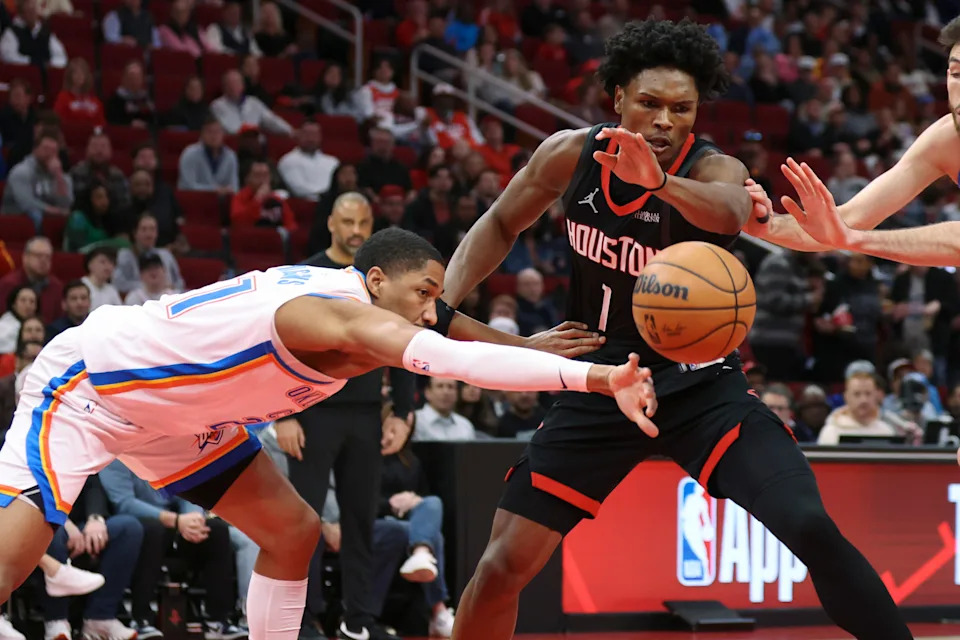 Jan 15, 2026; Houston, Texas, USA; Oklahoma City Thunder guard Aaron Wiggins (21) and Houston Rockets guard Amen Thompson (1) battle for the ball during the first quarter at Toyota Center. Mandatory Credit: Troy Taormina-Imagn Images