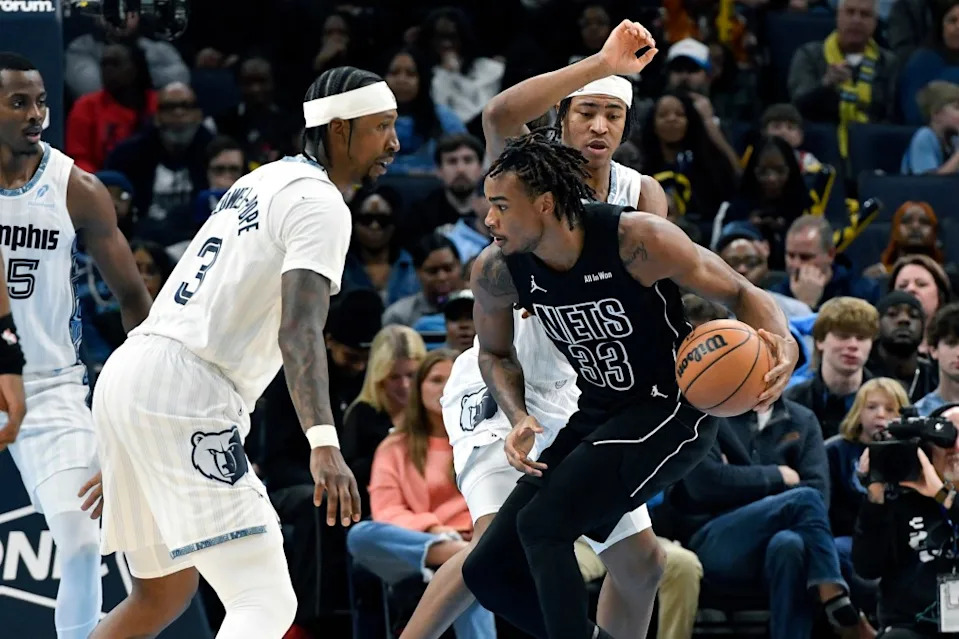 Brooklyn Nets center Nic Claxton (33) handles the ball against Memphis Grizzlies guard Kentavious Caldwell-Pope (3) and forward Jaylen Wells, top right, in the first half of an NBA basketball game Sunday, Jan. 11, 2026, in Memphis, Tenn. AP