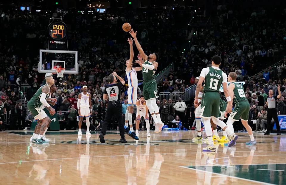 Jan 21, 2026; Milwaukee, Wisconsin, USA; Jump ball to start the game between Milwaukee Bucks forward Giannis Antetokounmpo (34) and Oklahoma City Thunder center/forward Chet Holmgren (7) in the first half at Fiserv Forum. Mandatory Credit: Michael McLoone-Imagn Images
