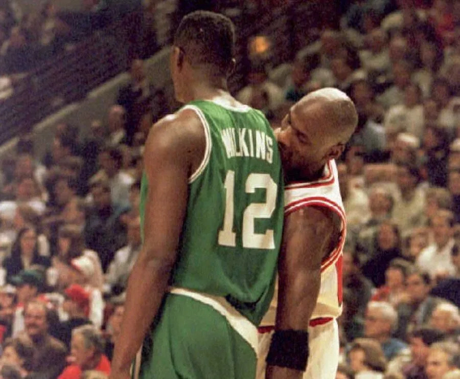 CHICAGO, IL - MARCH 30: Michael Jordan (R) of the Chicago Bulls jokes with Boston Celtics forward Dominique Wilkins (L), pretending to pull down his pants, in the second quarter 30 March at the United Center in Chicago. (Photo credit should read BRIAN BAHR/AFP via Getty Images)
