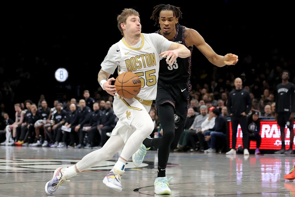 Jan 23, 2026; Brooklyn, New York, USA; Boston Celtics guard Baylor Scheierman (55) drives to the basket against Brooklyn Nets center Nic Claxton (33) during the second quarter at Barclays Center. Mandatory Credit: Brad Penner-Imagn Images