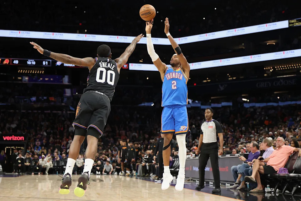 PHOENIX, ARIZONA - JANUARY 04: Shai Gilgeous-Alexander #2 of the Oklahoma City Thunder attempts a three-point shot against Royce O'Neale #00 of the Phoenix Suns during the second half of the NBA game at Mortgage Matchup Center on January 04, 2026 in Phoenix, Arizona. The Suns defeated the Thunder 108-105. NOTE TO USER: User expressly acknowledges and agrees that, by downloading and or using this photograph, user is consenting to the terms and conditions of the Getty Images License Agreement. (Photo by Christian Petersen/Getty Images)