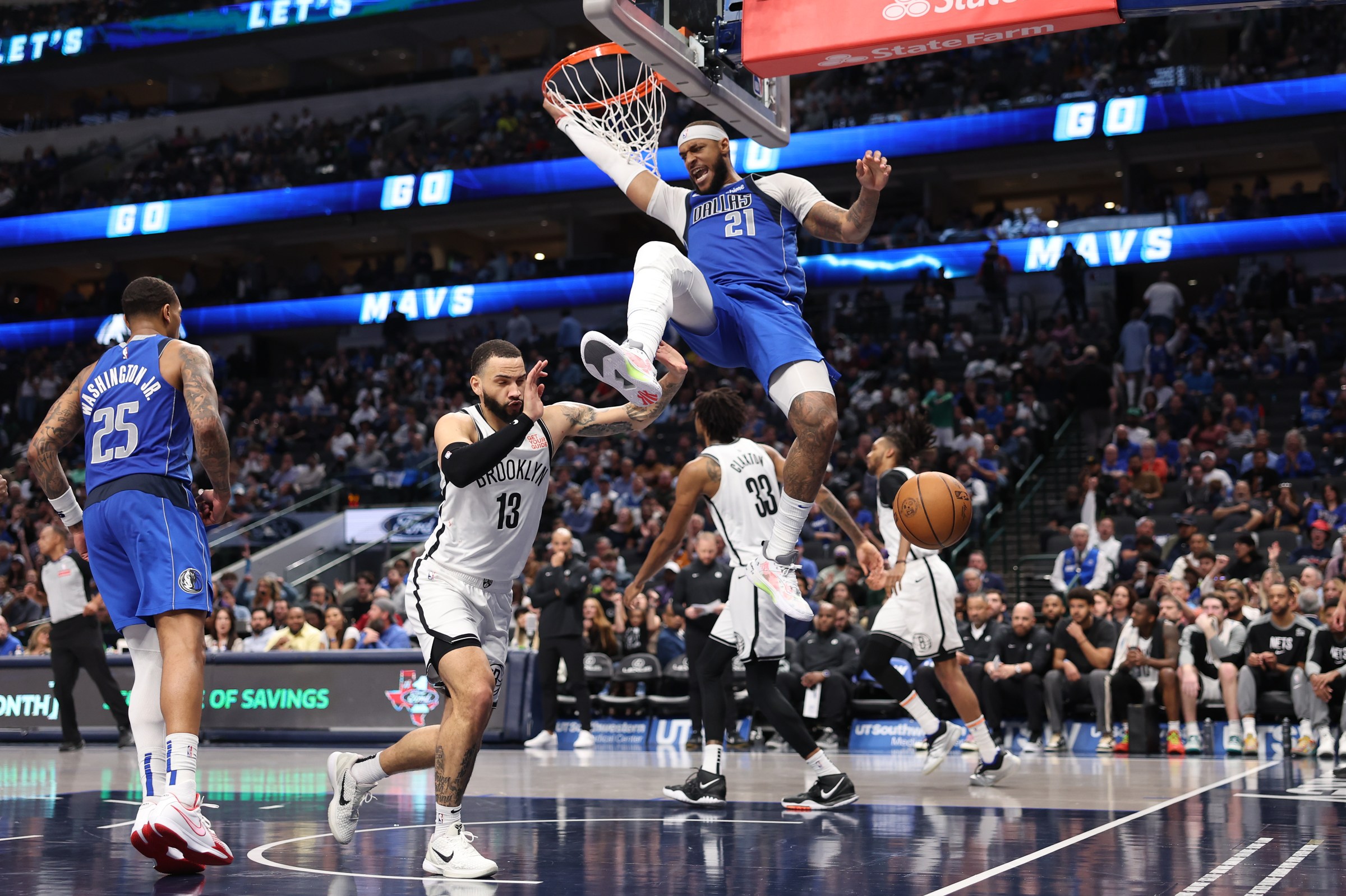 DALLAS, TEXAS - MARCH 31: Daniel Gafford #21 of the Dallas Mavericks hangs on the rim after dunking during the second half against the Brooklyn Nets at American Airlines Center on March 31, 2025 in Dallas, Texas. NOTE TO USER: User expressly acknowledges and agrees that, by downloading and/or using this photograph, user is consenting to the terms and conditions of the Getty Images License Agreement. (Photo by Sam Hodde/Getty Images)